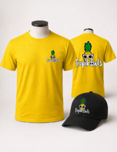 Bright yellow T-shirt featuring a pineapple wearing sunglasses logo (TropikOwls) on the chest; back view shows a larger logo. Includes a matching black cap with the same pineapple emblem.