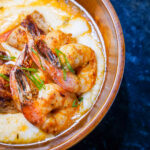 Shrimp and creamy sauce in a skillet, garnished with herbs, photographed from above.